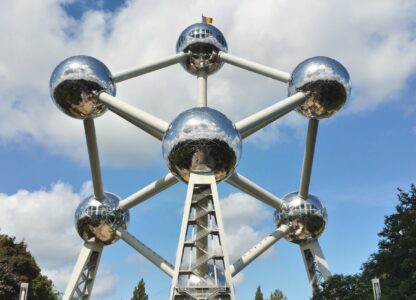Het Atomium in Brussel, een prachtig hoogtepunt van België, bestaat uit aaneengesloten metalen bollen die glinsteren tegen een blauwe lucht met donzige wolken: een perfect momentopname voor uw vakantieherinneringen.